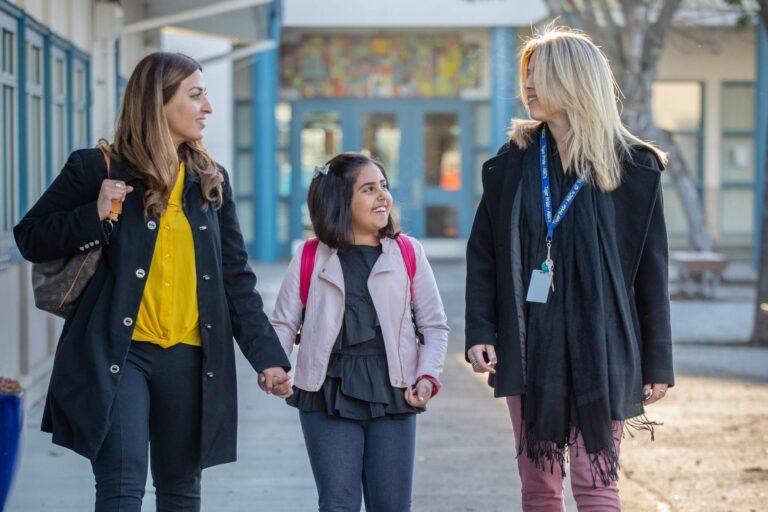 Seesaw teacher walking with student and parent to class