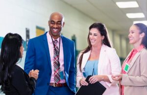 Administrators and teachers talking in the hallway of a school