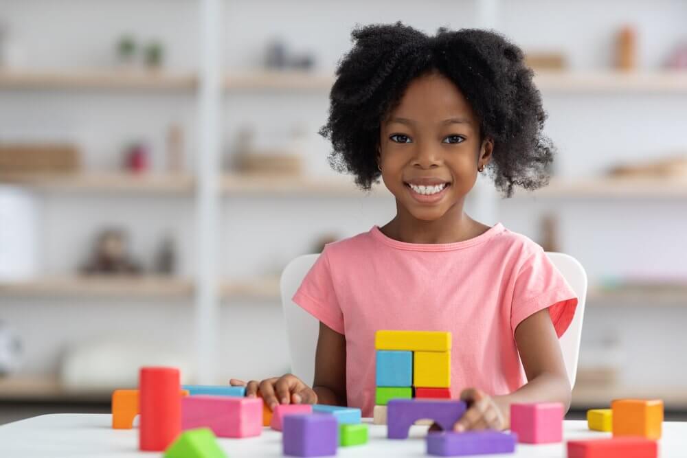 Student playing with blocks smiling